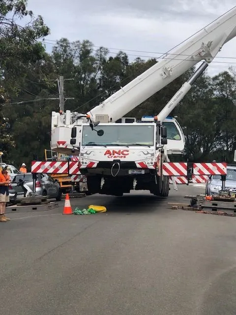 Crane truck and traffic control on a street after a tree came down